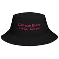 Black bucket hat from Petals & Ash Studio with "Capture Every Little Moment" text, casual style, front view.